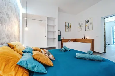 a bedroom with a blue bed with pillows on it at N'amuri in Palermo