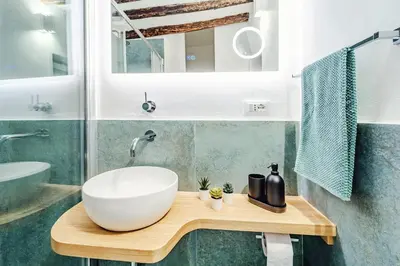 a bathroom with a large white bowl sink on a wooden table at N'amuri in Palermo