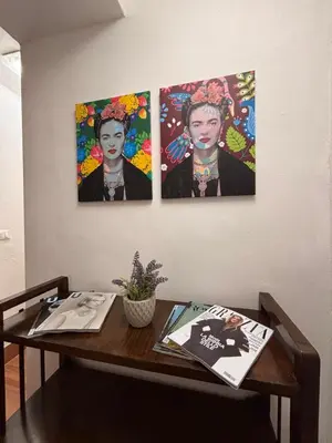 a table with three pictures of a woman on a wall at Houel's House in Palermo