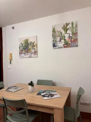 a dining room table with chairs and paintings on the wall at Houel's House in Palermo