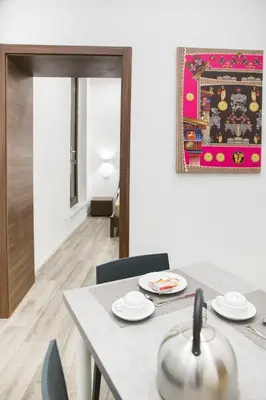 a dining room with a table and chairs and a rug at Apartments Porta di Castro in Palermo
