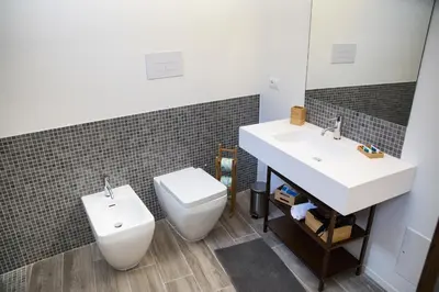 a bathroom with a sink and a toilet and a mirror at Apartments Porta di Castro in Palermo