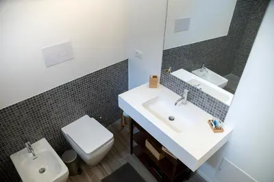 a bathroom with a sink and a toilet and a mirror at Apartments Porta di Castro in Palermo