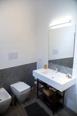 a bathroom with a sink and a toilet and a mirror at Apartments Porta di Castro in Palermo