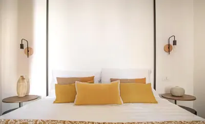 a bedroom with a white bed with yellow pillows at Il Moro & La Dama in Palermo