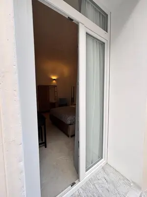 a sliding glass door leading to a bedroom at Historic Palazzo - Apartments & Rooms with Private Bathroom in Palermo