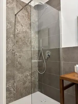 a shower with a glass door in a bathroom at Historic Palazzo - Apartments & Rooms with Private Bathroom in Palermo