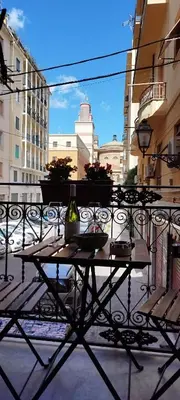 a table with a bottle of wine on a balcony at White House Theater Massimo in Palermo