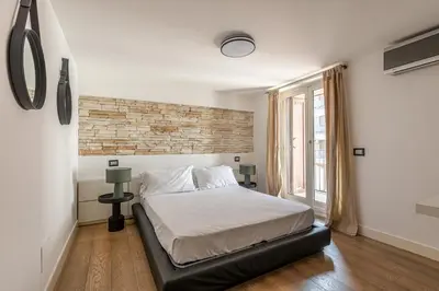 a bedroom with a bed and a brick wall at Appartamento Sammartino by Wonderful Italy in Palermo