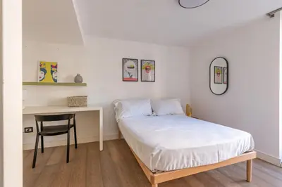 a bedroom with a bed and a desk and a chair at Appartamento Sammartino by Wonderful Italy in Palermo