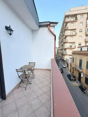a balcony with a table and chairs on a building at Casa Ragonese in Palermo