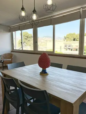 a large wooden table with chairs and a vase on it at Casa Ragonese in Palermo