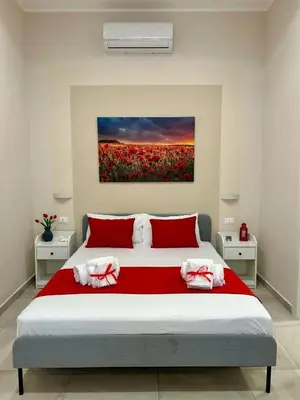 a bedroom with a large bed with red pillows at Casa Bontà in Palermo