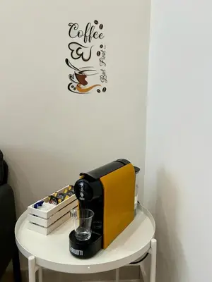 a coffee maker on a table with a coffee sign on a wall at Casa Bontà in Palermo