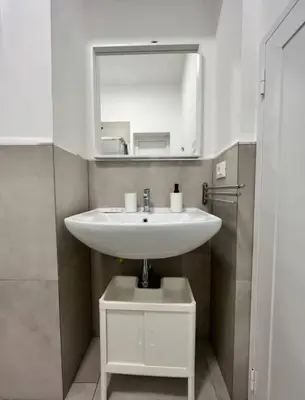 a bathroom with a white sink and a mirror at Casa Bontà in Palermo