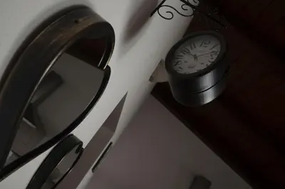 a clock hanging on a wall next to a mirror at Casa Vacanza Isola di Eufemio in Capaci