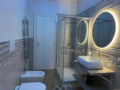 a bathroom with a sink and a toilet and a mirror at INFINITY Luxury Apartment in Palermo