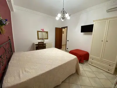 a bedroom with a bed and a dresser and a television at Le Ortensie Appartamento Grande in San Vito lo Capo