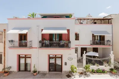 a white house with red accents at Le Ortensie Appartamento Grande in San Vito lo Capo
