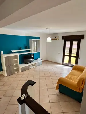 a patio with a table and a chair under it at A Casa Da Mari' in Terrasini