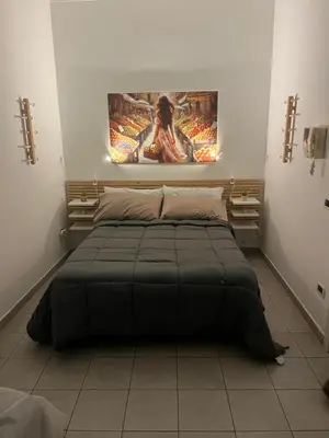 a bed in a room with a painting on the wall at Appartamento Ciccio al Capo in Palermo