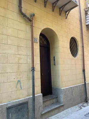 a brick building with a brown door and stairs at Appartamento Ciccio al Capo in Palermo