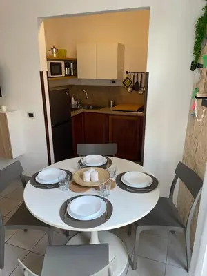 a kitchen with a white table with plates and chairs at Appartamento Ciccio al Capo in Palermo