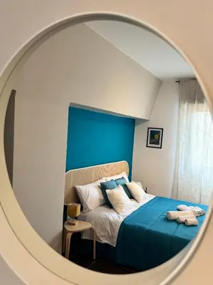 a bedroom with a bed with a blue wall at Maison N 16 in Palermo