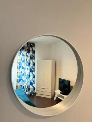 a mirror reflecting a living room with a television at Maison N 16 in Palermo
