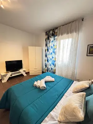 a bedroom with two towels on a large blue bed at Maison N 16 in Palermo