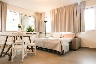 a bedroom with a bed and a table and chairs at Le Case del Massimo in centrocittà in Palermo