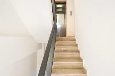 a staircase in a building with white walls and wooden floors at Le Case del Massimo in centrocittà in Palermo