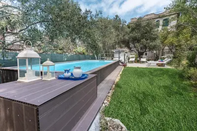 a swimming pool with a table and a lantern next to a yard at Villa Emma 50 mt from the sea with private pool in Carini