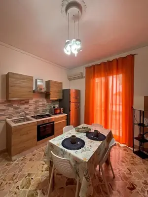 a kitchen with a table with two chairs in it at La rosa dei venti in Isola delle Femmine