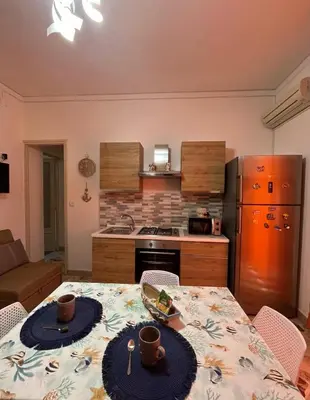 a kitchen with a table and a kitchen with a refrigerator at La rosa dei venti in Isola delle Femmine