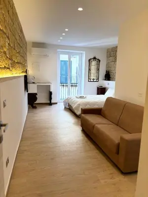 a living room with a couch and a bed at Palermo Sunset in Palermo