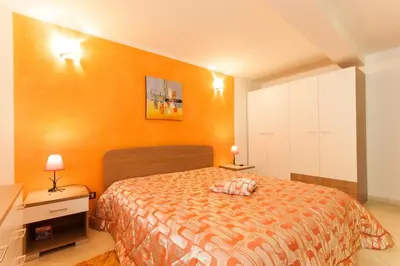 a bedroom with a bed and two night stands and two lamps at Casa vacanze Giusi in Castellammare del Golfo