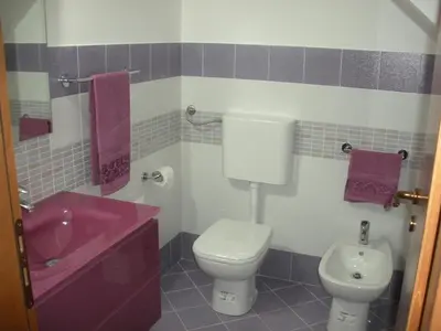 a bathroom with a pink sink and a toilet at Casa vacanze Giusi in Castellammare del Golfo
