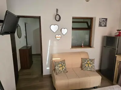 a living room with a couch and hearts on the wall at Casa Vacanza Isola di Eufemio Piano Terra in Capaci