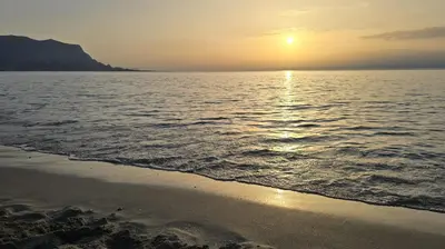 a beach with the sun setting over the water at Casa Vacanza Isola di Eufemio Piano Terra in Capaci