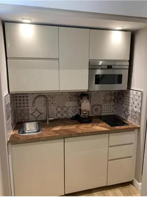 a kitchen with white cabinets and a sink and a microwave at Sperlinga Suite in Palermo