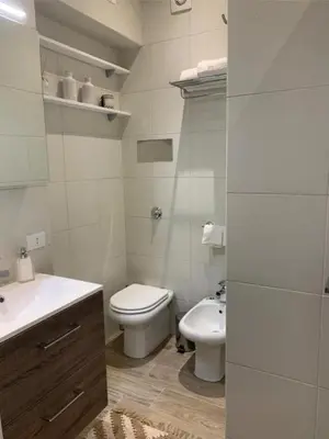 a white bathroom with a toilet and a sink at Sperlinga Suite in Palermo
