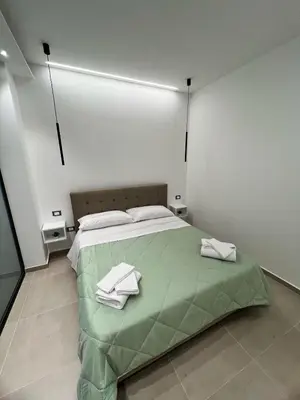 a bedroom with a green bed with towels on it at La Casetta di Sa Lu in Capaci