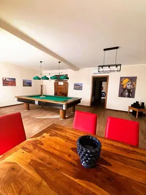 a room with a ping pong table and red chairs at Gira e Firria in Palermo
