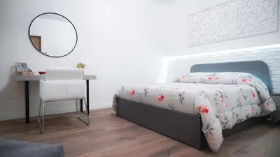 a bedroom with a bed and a mirror and a table at Gira e Firria in Palermo