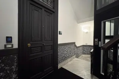 a hallway with a black door and a staircase at G Cave 125 Boutique Apartment in Palermo