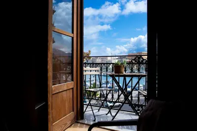 a balcony with a table and a view of the city at Vela House charming front of sea in Palermo