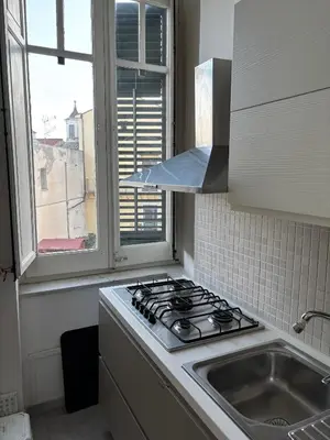 a kitchen with a stove and a sink and a window at La Casa di Alan in Palermo