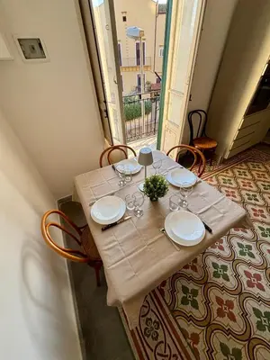 a table with plates and wine glasses on it at La Casa di Alan in Palermo