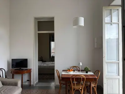 a dining room with a table and chairs and a living room at La Casa di Alan in Palermo